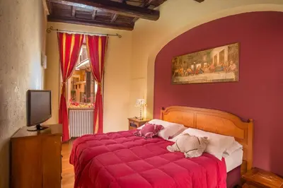 a red bedroom with a bed with a red blanket at Bollo Apartments in Rome