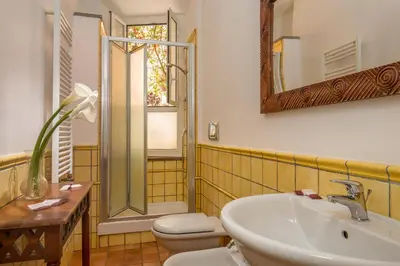 a bathroom with a sink and a toilet and a mirror at Bollo Apartments in Rome