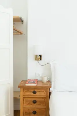 a bedroom with a wooden dresser next to a bed at Smart Lodgings Plus in Rome
