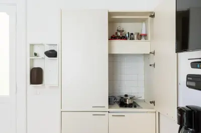 a white kitchen with white cabinets and appliances at Smart Lodgings Plus in Rome