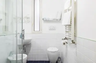 a white bathroom with a toilet and a sink at Smart Lodgings Plus in Rome