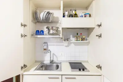 a small kitchen with a sink and white cabinets at Smart Lodgings Plus in Rome