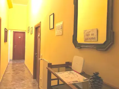 a yellow hallway with a table and a mirror at San Daniele Bundi House in Rome