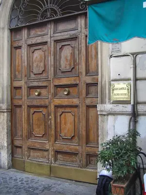 a large wooden door on the side of a building at San Daniele Bundi House in Rome