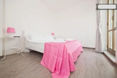 a bedroom with a table with a pink blanket on it at B&B Lost in Rome in Rome
