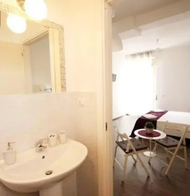 a bathroom with a sink and a mirror and a table at B&B Lost in Rome in Rome
