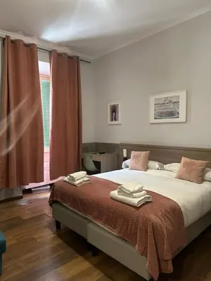 a white bed with pillows on it in a bedroom at Alea Home Roma in Rome
