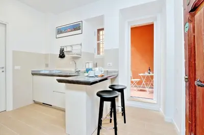 a kitchen with a counter and two stools at Deco's Place Roma Zoe in Rome