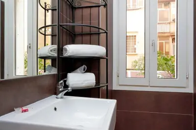 a white bedroom with a bed and a table at Deco's Place Roma Zoe in Rome