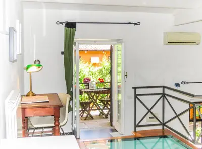 a room with a desk and a door leading to a patio at Casa del Moro - romantic loft in Trastevere in Rome