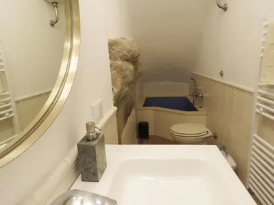 a bathroom with a sink and a toilet with a mirror at Casa del Moro - romantic loft in Trastevere in Rome