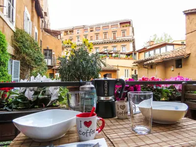 a table with two bowls and cups on a balcony at Casa del Moro - romantic loft in Trastevere in Rome