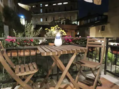 a wooden table with two chairs and a vase on it at Casa del Moro - romantic loft in Trastevere in Rome