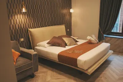 a bedroom with a bed and a chair in it at Hotel Roma Vaticano in Rome