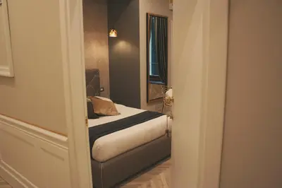 a small bedroom with a bed and a mirror at Hotel Roma Vaticano in Rome