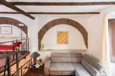 a living room with a couch and a staircase at Cedro Terrace&Jacuzzi - Loft in Trastevere in Rome