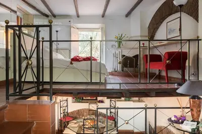 a bedroom with a large bed and a room with a table at Cedro Terrace&Jacuzzi - Loft in Trastevere in Rome