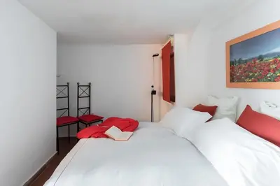 a bedroom with two white beds and red pillows at Cedro Terrace&Jacuzzi - Loft in Trastevere in Rome