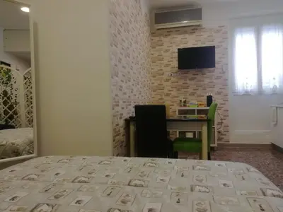 a bedroom with a bed and a desk and a television at Apartment Urbino 33 in Rome