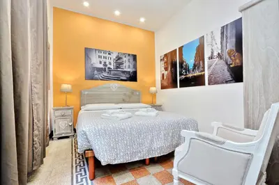 a small bedroom with a bed and two chairs at Restart Zingari Rome in Rome
