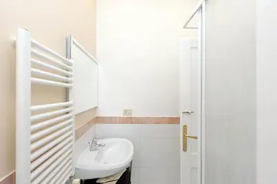 a white bathroom with a sink and a mirror at Restart Zingari Rome in Rome