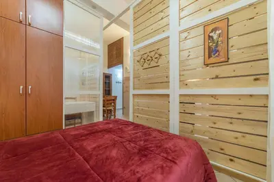 a bedroom with a bed and a wall of wood at Vittorio Emmanuele & Colosseo Studio in Rome