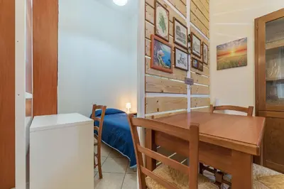 a kitchen and dining room with a table and a refrigerator at Vittorio Emmanuele & Colosseo Studio in Rome