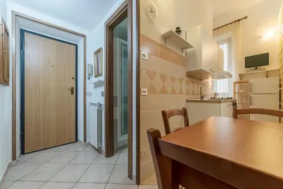 a kitchen and dining room with a table and a door at Vittorio Emmanuele & Colosseo Studio in Rome