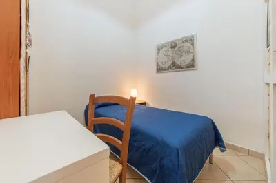 a room with a bed with a blue blanket and a table at Vittorio Emmanuele & Colosseo Studio in Rome