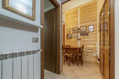 a dining room with a table and a wooden wall at Vittorio Emmanuele & Colosseo Studio in Rome