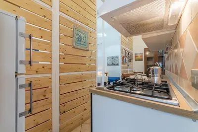 a kitchen with wooden walls and a stove at Vittorio Emmanuele & Colosseo Studio in Rome