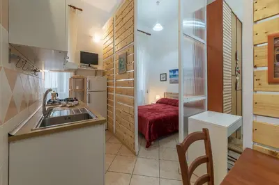 a kitchen with a sink and a room with a bed at Vittorio Emmanuele & Colosseo Studio in Rome