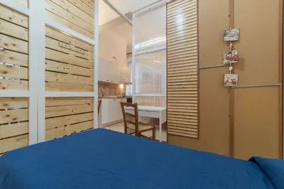 a bedroom with a blue bed and a desk at Vittorio Emmanuele & Colosseo Studio in Rome