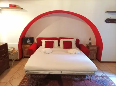a bedroom with a bed with a red and white headboard at Colosseo Home - 29061 in Rome