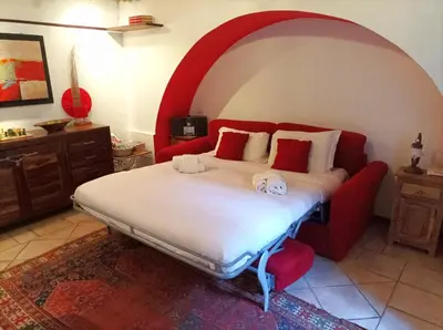 a bedroom with a large bed with a red couch at Colosseo Home - 29061 in Rome