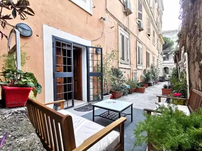 a patio with a table and benches in front of a building at Colosseo Home - 29061 in Rome