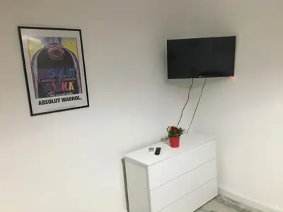 a tv on a wall next to a white dresser at OASI METROPOLITANA Apartment in Rome
