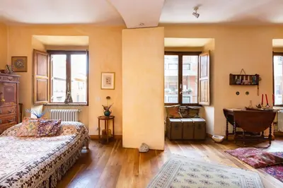 a bedroom with two beds and a table and windows at Charming Bright Colosseum apartment in Rome