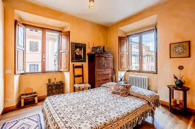 a bedroom with a bed and two windows at Charming Bright Colosseum apartment in Rome