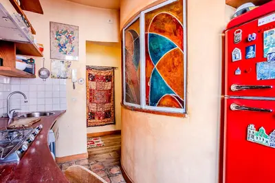 a kitchen with a red refrigerator with a stained glass window at Charming Bright Colosseum apartment in Rome