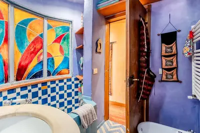 a bathroom with a sink and a painting on the wall at Charming Bright Colosseum apartment in Rome