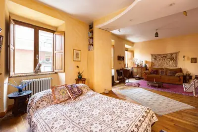 a bedroom with a bed and a living room at Charming Bright Colosseum apartment in Rome