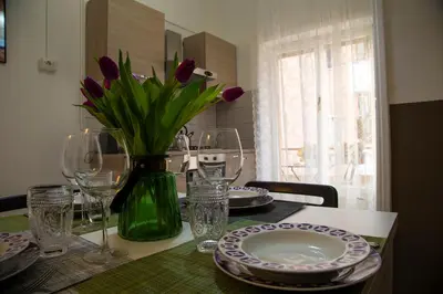 a dining room table with a vase of purple tulips at San Silverio Luxury House in Rome
