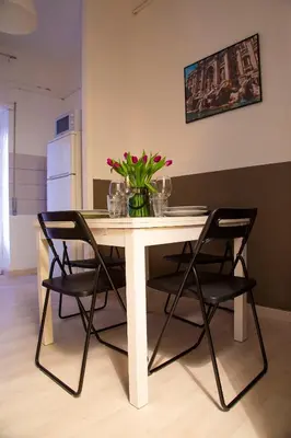 a table with chairs and a vase of flowers on it at San Silverio Luxury House in Rome