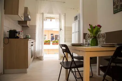a kitchen with a table with flowers on it at San Silverio Luxury House in Rome