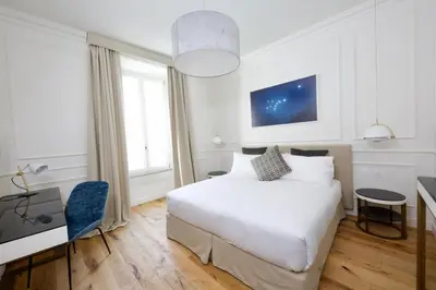 a bedroom with a white bed and a desk and window at Parisii Luxury Relais Rome in Rome