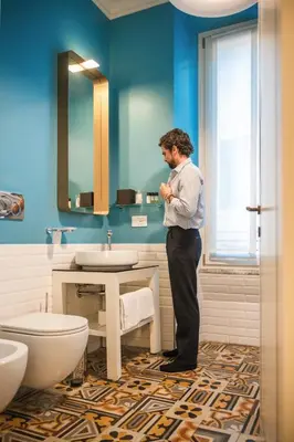 a man standing in a bathroom next to a sink at Parisii Luxury Relais Rome in Rome