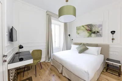 a bedroom with a bed and a desk and a television at Parisii Luxury Relais Rome in Rome