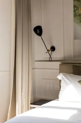 a bedroom with a bed and a lamp on a wall at Parisii Luxury Relais Rome in Rome