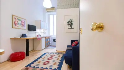 a living room with a blue couch and a kitchen at Rental in Rome Pompeo Magno in Rome